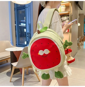 Detail of cute watermelon backpack featuring cartoon face and plush apple pendant