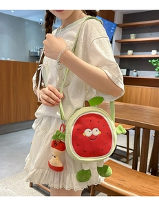 Close-up of fruit-themed round shoulder bag with apple core pendant in a cafe setting