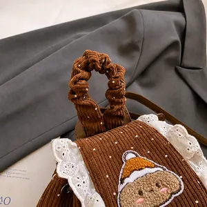 Détail de la poignée en velours avec dentelle blanche et broderie d'ourson mignon