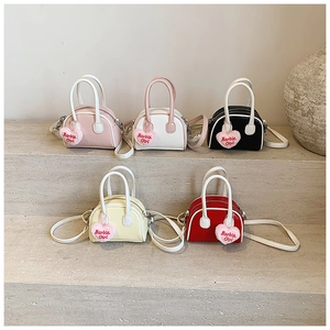 Detail of five mini shell bags in various colors featuring Barbie Girl heart plush pendants