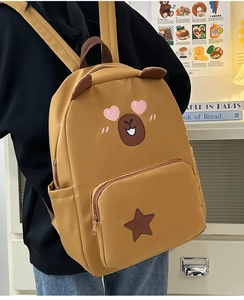 Détails de la broderie capybara et du patch étoile sur le sac à dos jaune mignon