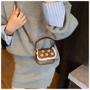 Détail d'un mini sac bandoulière en cuir PU marron avec fleurs et bord en dentelle