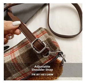 Close-up of adjustable shoulder strap with silver buckle on brown plaid plush bag