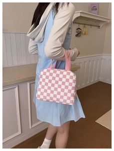 Detail shot of a pink and white checkered lunch bag featuring sturdy woven handles