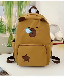 Détail d'un sac à dos jaune avec broderie ours et écusson étoile dans un décor douillet