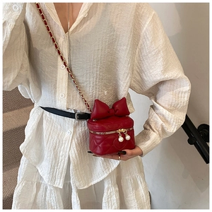 Detail of red quilted mini box bag with large bow and pearl zipper pendants for kids
