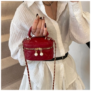 Détail du mini sac boîte rouge matelassé avec chaîne dorée et perles décoratives