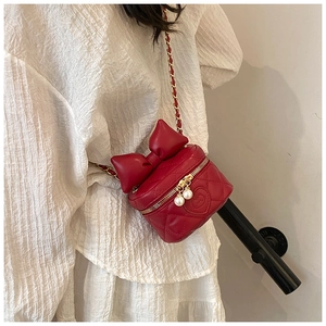 Close-up of red quilted leather kid bag with large bow and Hello Kitty detail