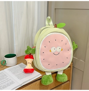 Detailed view of sweet pitaya cartoon plush backpack with cute fruit pendant on wooden table