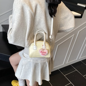 Mini yellow shell bag for kids with white handles and a plush Barbie Girl heart charm