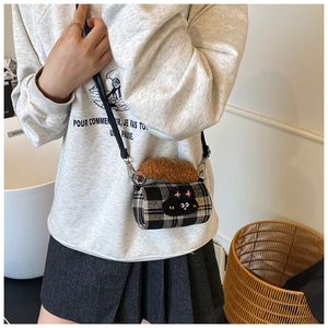 Close-up of mini checkered crossbody bag with cat embroidery and plush handle detail