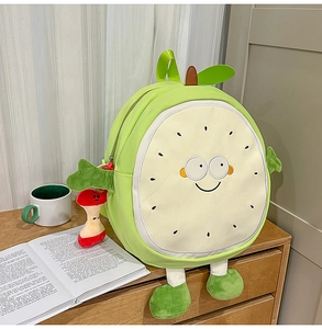 Close-up of cute cartoon guava backpack with plush fruit charm on a wooden table