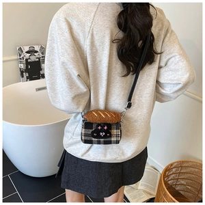 Detail of mini plaid crossbody bag featuring a cute cat embroidery and plush bread ornament