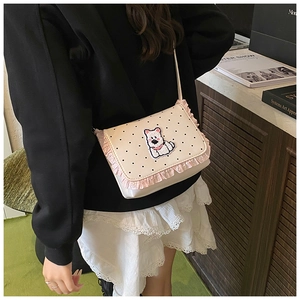 Close-up of cute polka dot crossbody bag with cartoon dog patch and pink ruffled trim
