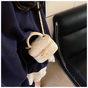 Vue détaillée du sac matelassé crème pour enfants avec zip perle et bandoulière
