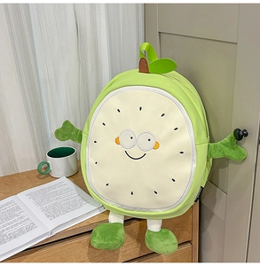 Close-up of cute green guava fruit plush backpack with cartoon face on wooden desk