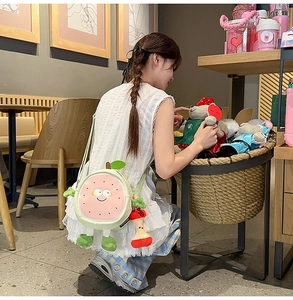 Detailed close-up of a cartoon fruit crossbody bag with apple pendant and cute smile