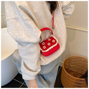 Vue détaillée du mini sac rouge avec dentelle et ornements de fleurs en relief