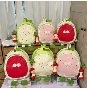 Detail of cute dragon fruit backpacks in red, pink, and beige with soft plush charms