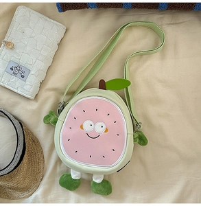 Detail of plush fruit-shaped crossbody bag with cute facial expression and soft strap