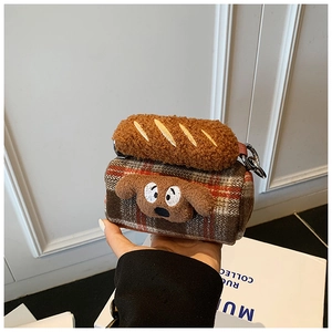 Detail of plush brown plaid mini bag with cute cartoon dog face and metal carabiner hook
