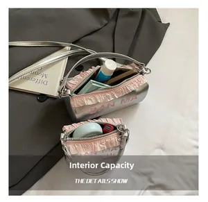 Détail de la capacité intérieure du sac cylindrique argenté avec froufrou rose et maquillage