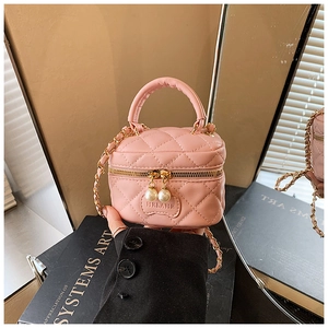 Détail du mini sac matelassé rose avec breloques perles et bandoulière dorée