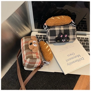 Detailed view of plaid wool texture and plush animal embroidery on kid shoulder bags