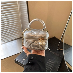 Détail du mini sac argenté matelassé avec fermetures perles et bandoulière chaîne