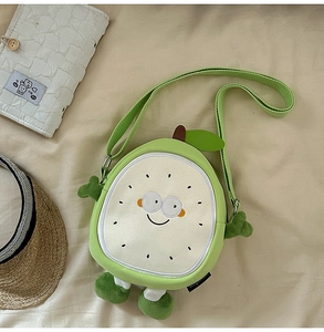 Detail of cute green fruit crossbody bag with cartoon eyes and plush 3D limbs