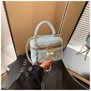 Détail du mini sac matelassé bleu ciel avec tirettes de perles et bandoulière en chaîne métal
