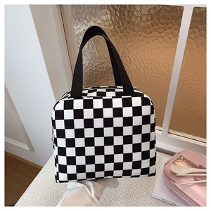 Detail of checkered lunch bag with sturdy black handles and thermal insulated interior