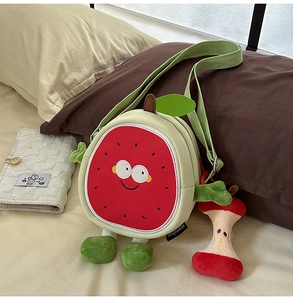 Close-up of cute cartoon watermelon crossbody bag with a small apple core charm