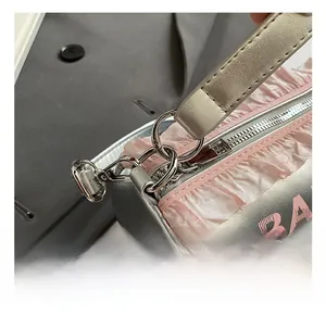 Détail du sac barillet argenté métallisé avec bordure en dentelle rose et crochet