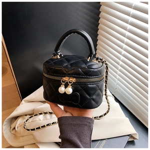 Détail du mini sac boîte noir matelassé avec élégantes doubles tirettes en perles