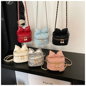 Detailed view of kids quilted crossbody bags with bow accent and pearl zipper pulls