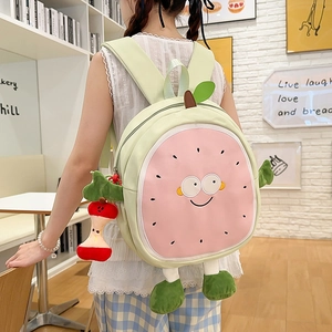 Cute green cartoon fruit backpack for students with pink smiling face and apple charm