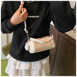 Detail of cream barrel bag with pink lace trim and letter print worn by child model