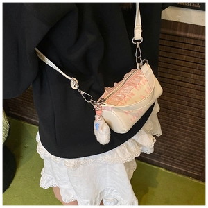 Détail du sac enfant crème avec volants roses, imprimé lettres et breloque en peluche