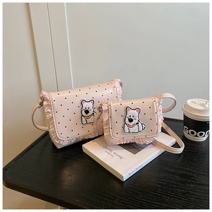 Detail der rosa gepunkteten Kindertasche mit Spitzenborte und Welpenbestickung