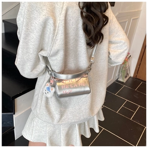 Détail du mini sac barillet argenté avec lettrage rose et porte-clé ours blanc mignon
