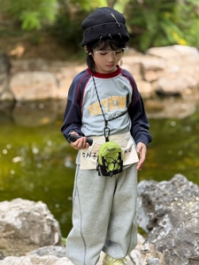 Close-up of kids' avocado green and black mini crossbody bag for outdoor travel use