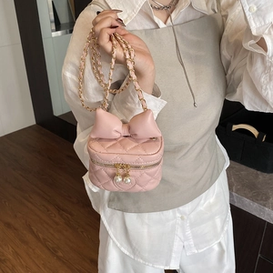 Pink quilted crossbody bag for kids featuring a large bow and pearl zipper charms