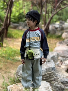 Close-up of a neon green mini crossbody bag styled on a trendy child's streetwear outfit