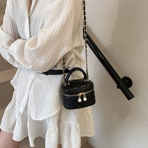 Mini sac à bandoulière noir matelassé pour enfants avec perle porté par un mannequin
