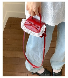 Detailed view of red mini purse with white lace edges and a 3D decorative bow on top
