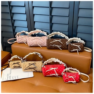 Minibolsos cilíndricos de lunares en varios colores con asas de encaje y lazos decorativos