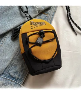 Detail of yellow and black mini crossbody bag with Fingercroxx logo and carabiner