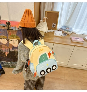 Rear view of a child wearing a cute yellow and blue submarine cartoon backpack at home