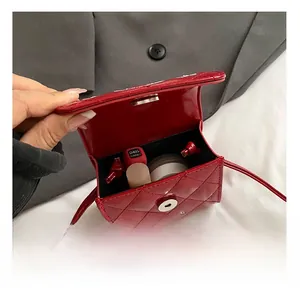 Detail view of red quilted mini crossbody bag showing interior lipstick storage capacity